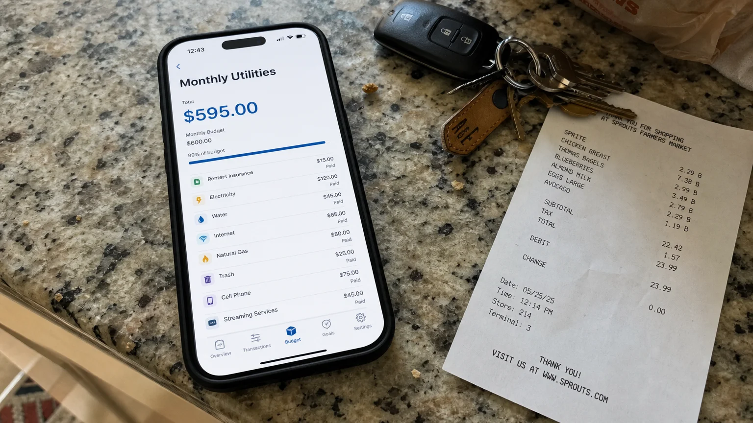 A smartphone screen on a kitchen counter displaying a utility budget of $595.00.